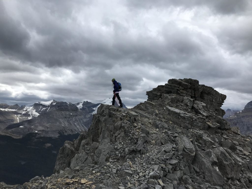 Person standing on a mountain top. Hiking can be relaxing.